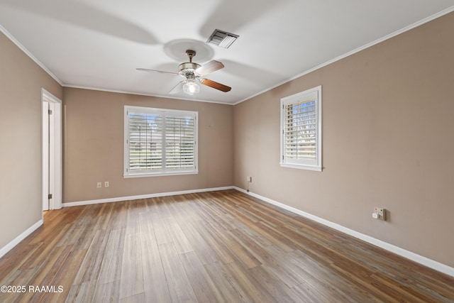 unfurnished room with wood finished floors, baseboards, visible vents, ceiling fan, and ornamental molding