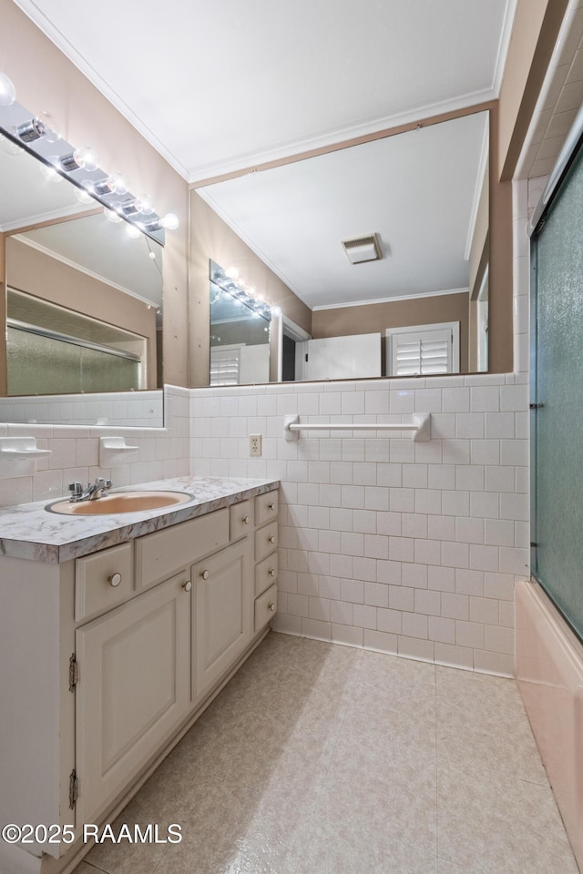 bathroom with tile patterned floors, tile walls, vanity, and ornamental molding