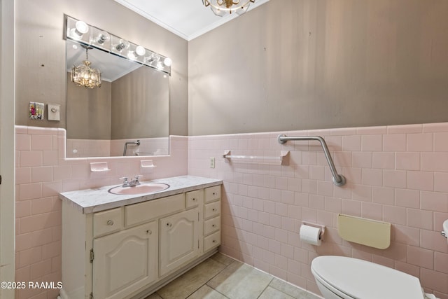 bathroom featuring tile patterned flooring, wainscoting, tile walls, and crown molding