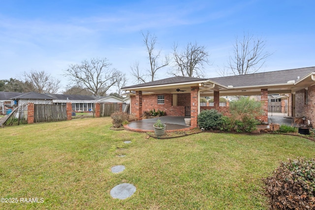 back of house featuring brick siding, fence, a patio, a yard, and a ceiling fan