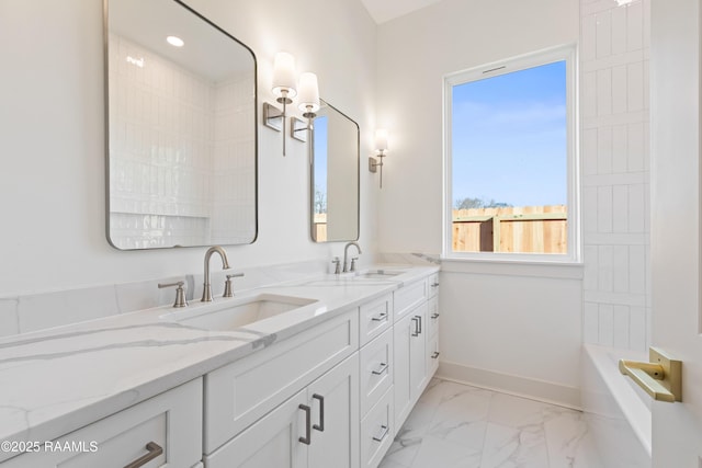 full bath with marble finish floor, a sink, baseboards, and double vanity