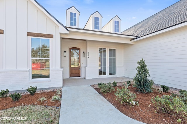 entrance to property featuring board and batten siding and brick siding