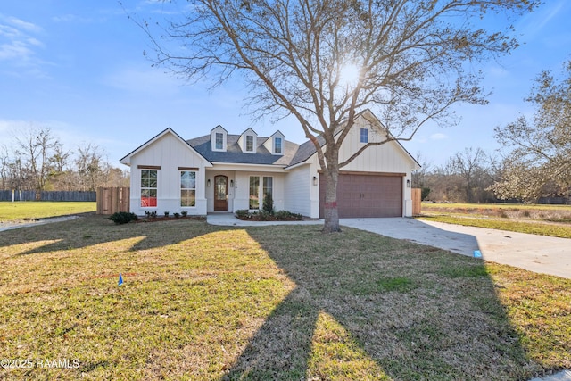 view of front of home with a garage, driveway, a front yard, and fence