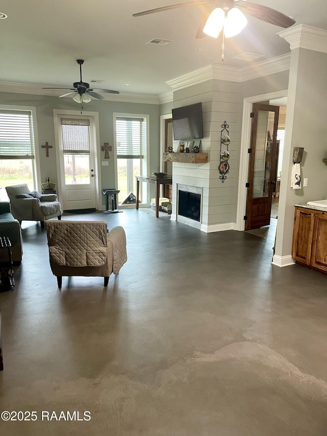 living area with concrete flooring, visible vents, a fireplace, and crown molding