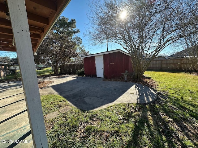 exterior space featuring a storage shed, a patio area, an outdoor structure, and a fenced backyard