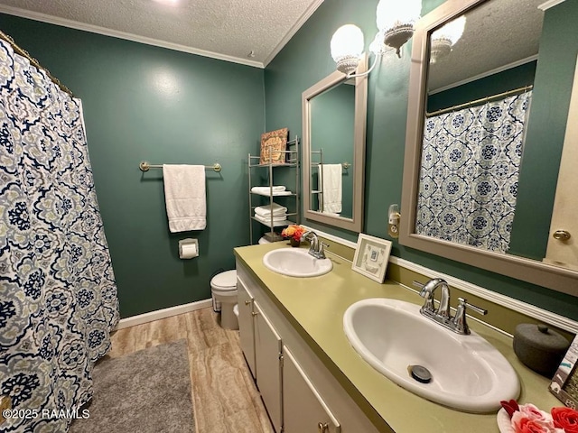 full bath with a textured ceiling, ornamental molding, wood finished floors, and a sink