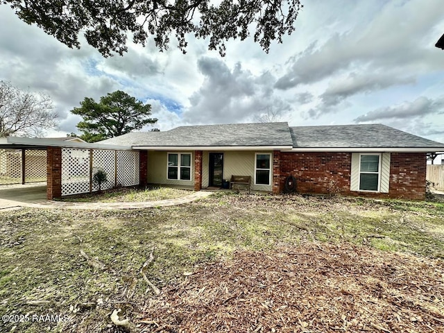 view of front of home featuring a carport and brick siding