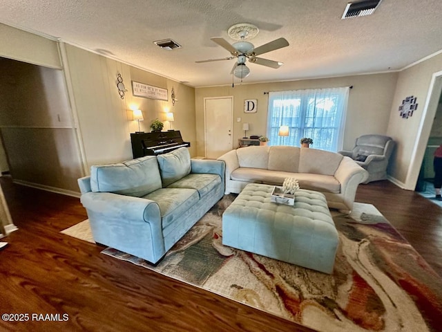 living area with ornamental molding, wood finished floors, and visible vents