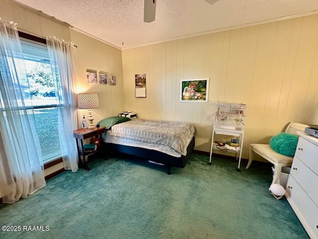 carpeted bedroom with ceiling fan, ornamental molding, and a textured ceiling