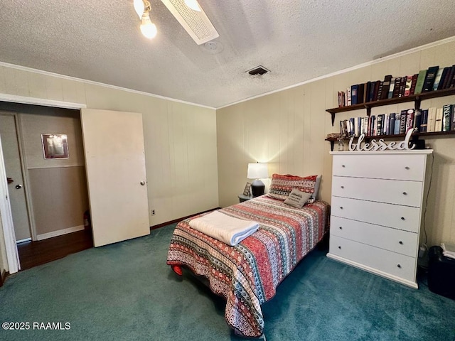 bedroom featuring visible vents, a textured ceiling, ornamental molding, and carpet flooring