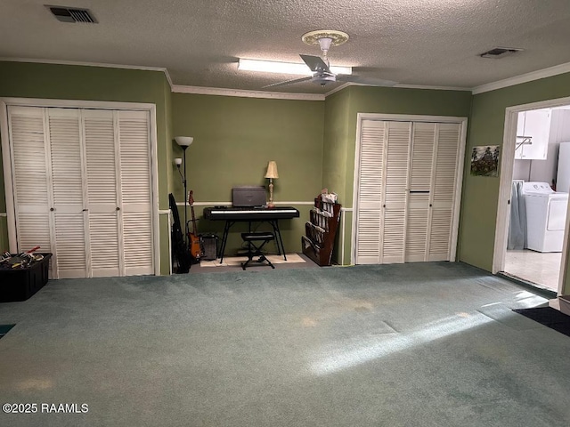 interior space with visible vents, washer and dryer, and ornamental molding