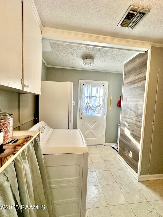 washroom featuring cabinet space, a textured ceiling, visible vents, and crown molding