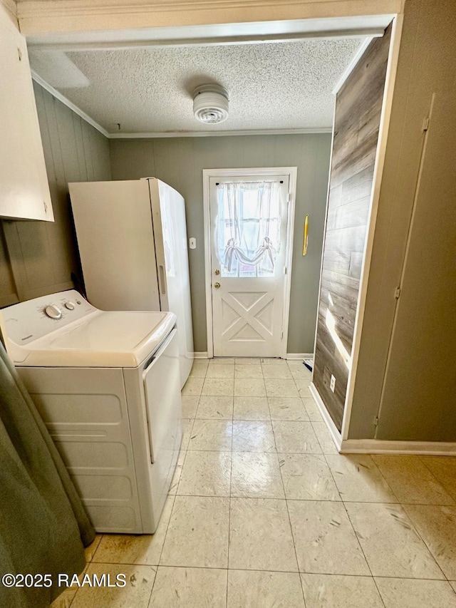 washroom featuring crown molding, cabinet space, wood walls, a textured ceiling, and independent washer and dryer