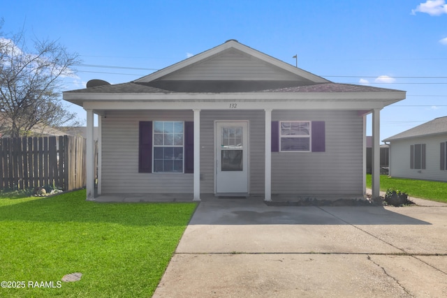 bungalow with a front yard, covered porch, and fence