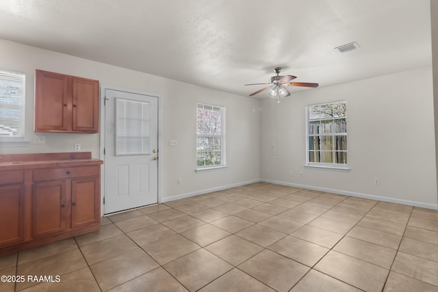 unfurnished dining area with baseboards, plenty of natural light, visible vents, and a ceiling fan