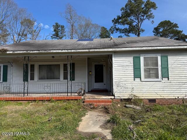 view of front facade with crawl space, covered porch, and a front yard