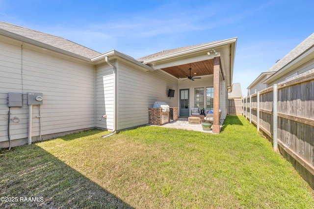 rear view of house featuring a yard, a patio area, a fenced backyard, and a ceiling fan