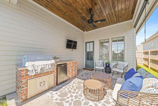 view of patio featuring ceiling fan, grilling area, an outdoor kitchen, and fence