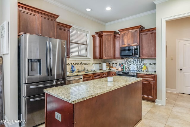 kitchen with a sink, stainless steel appliances, a kitchen island, and light stone countertops