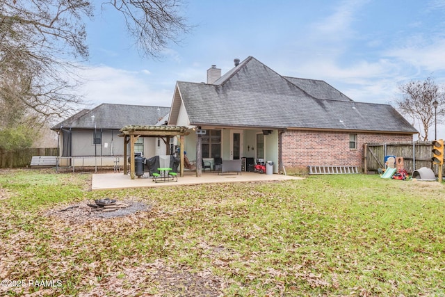 back of property featuring a chimney, fence, a yard, a patio area, and a pergola