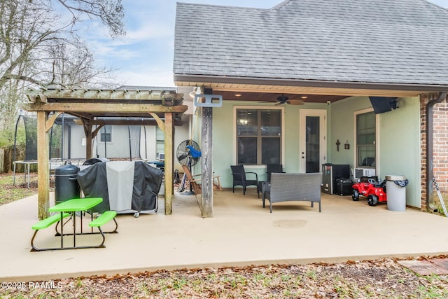 exterior space featuring brick siding, a shingled roof, a ceiling fan, and a patio