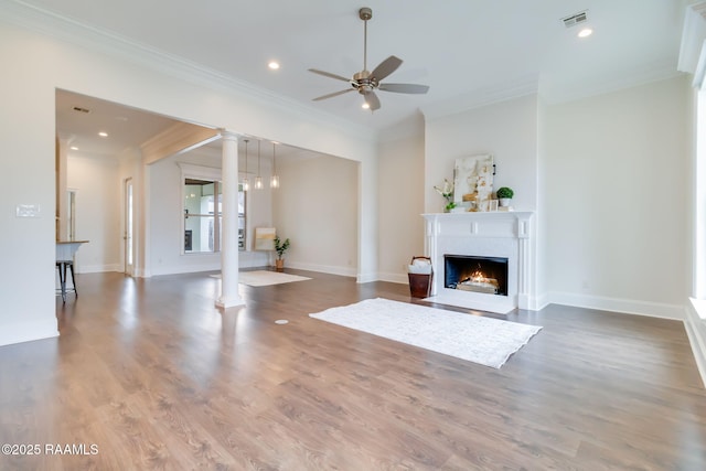 unfurnished living room featuring decorative columns, visible vents, a fireplace with flush hearth, ceiling fan, and wood finished floors