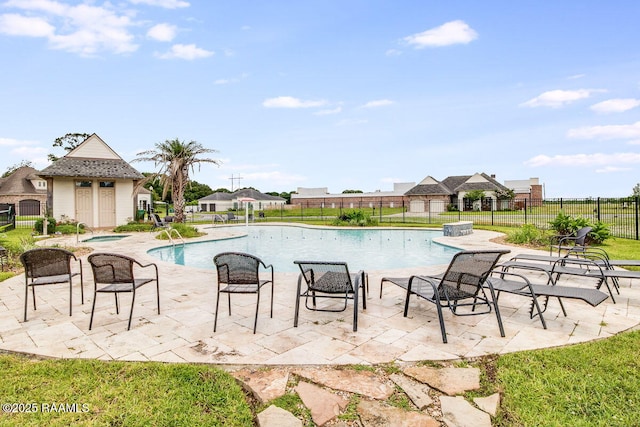 pool with a patio area, a residential view, fence, and a community hot tub