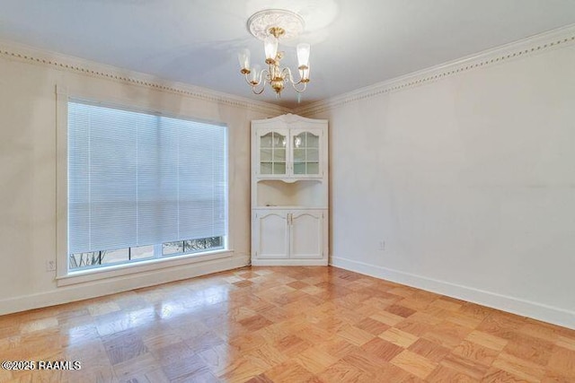 unfurnished room with baseboards, a chandelier, and crown molding