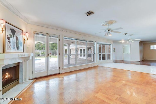 unfurnished living room with plenty of natural light, french doors, visible vents, and a premium fireplace