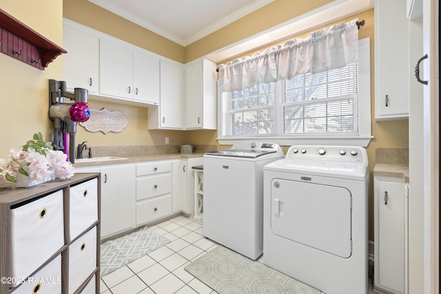 laundry room featuring crown molding, light tile patterned floors, cabinet space, a sink, and separate washer and dryer