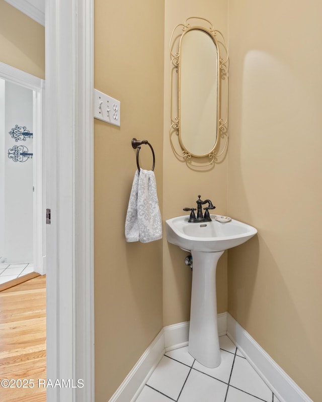 bathroom with baseboards, a sink, and tile patterned floors