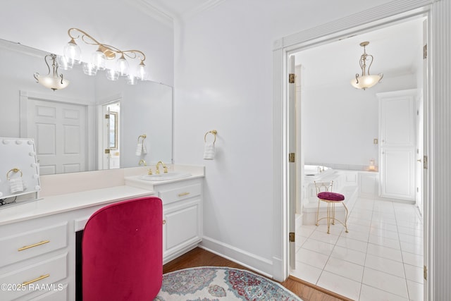 full bath featuring ornamental molding, vanity, tile patterned flooring, baseboards, and a bath