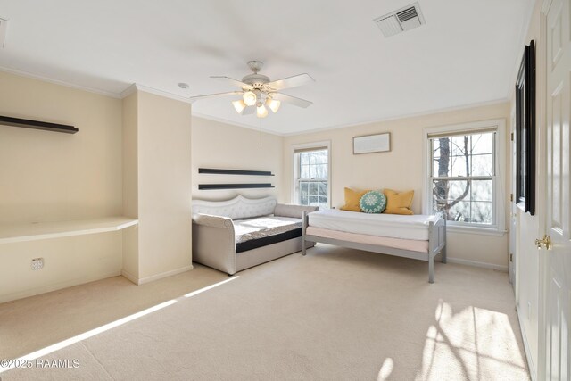 carpeted bedroom with baseboards, ceiling fan, visible vents, and crown molding