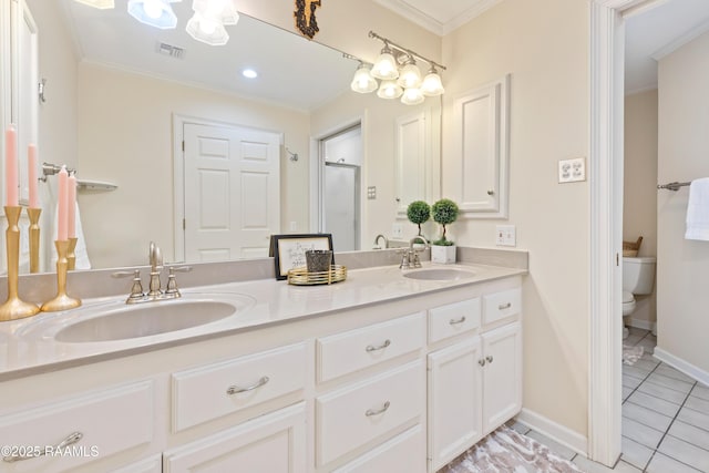 full bath featuring toilet, crown molding, double vanity, and a sink