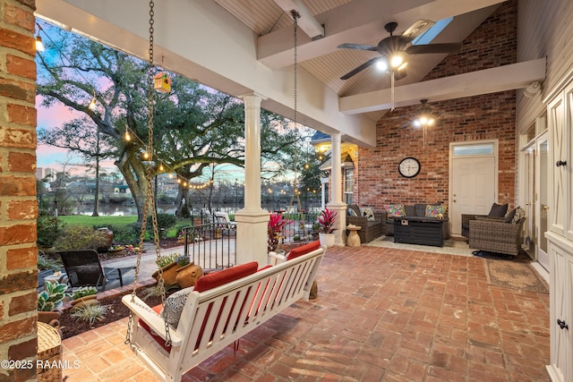 patio terrace at dusk featuring a ceiling fan and an outdoor hangout area