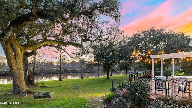 view of home's community with a water view and a yard