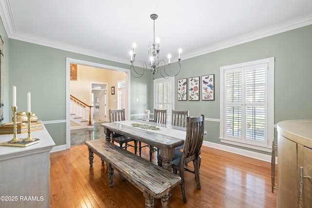 dining area with ornamental molding, stairway, light wood-type flooring, and a healthy amount of sunlight