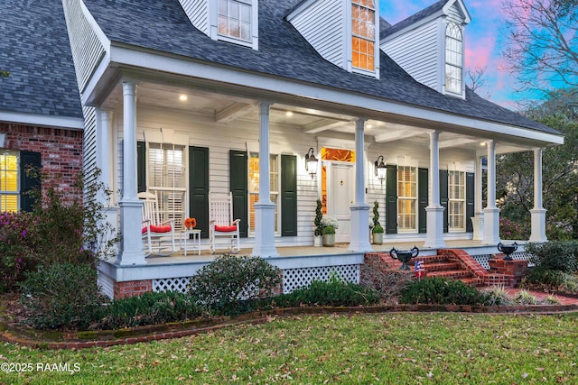 exterior space featuring a porch, a shingled roof, and brick siding