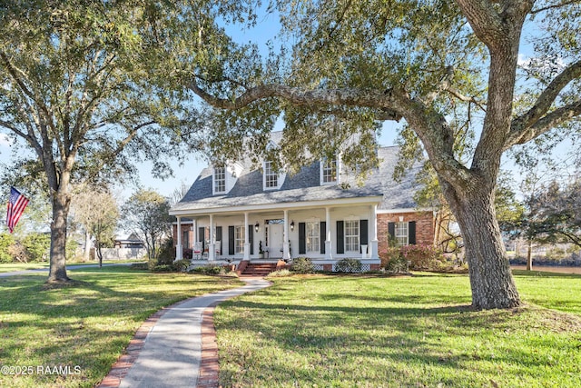 cape cod house with a porch, roof with shingles, and a front lawn