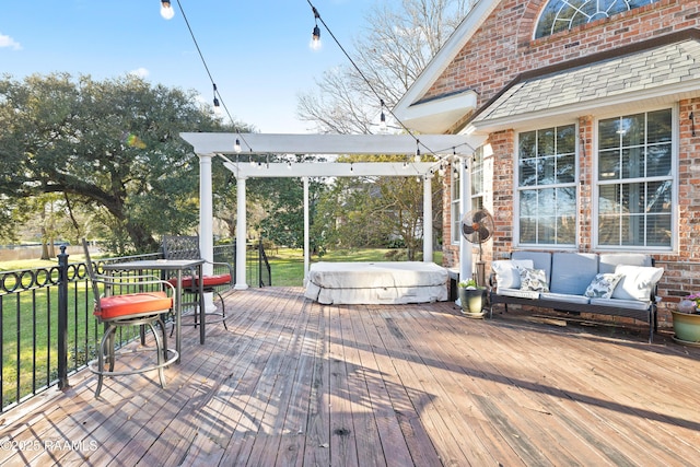 wooden terrace with a yard, outdoor lounge area, and a covered hot tub