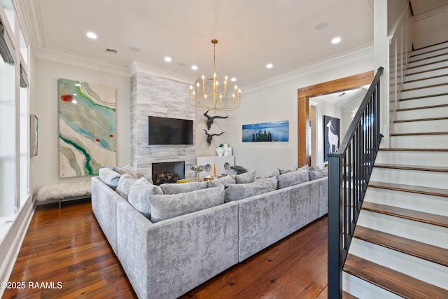 living room featuring a large fireplace, stairway, dark wood-style floors, and ornamental molding