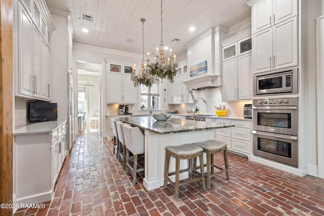 kitchen featuring appliances with stainless steel finishes, wood ceiling, brick floor, and white cabinetry