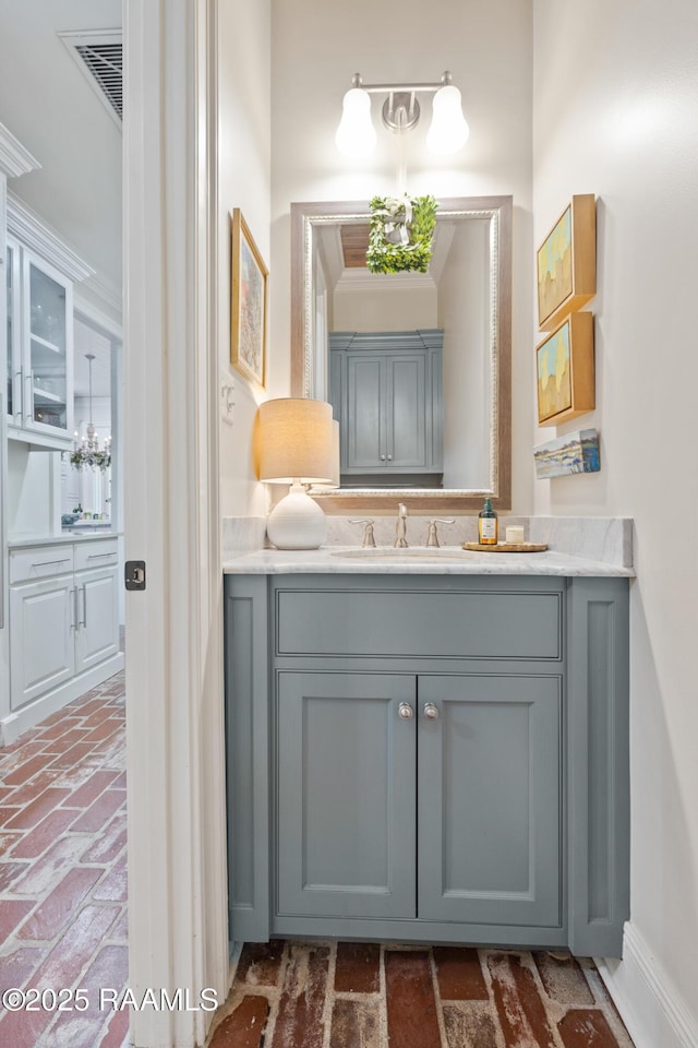 bathroom with brick floor, visible vents, and vanity