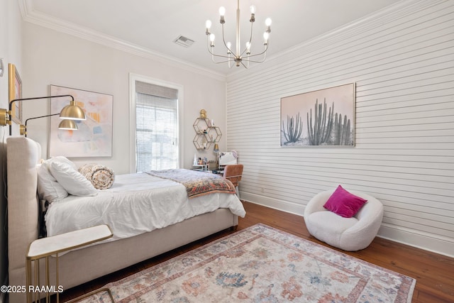 bedroom featuring baseboards, visible vents, wood finished floors, and ornamental molding