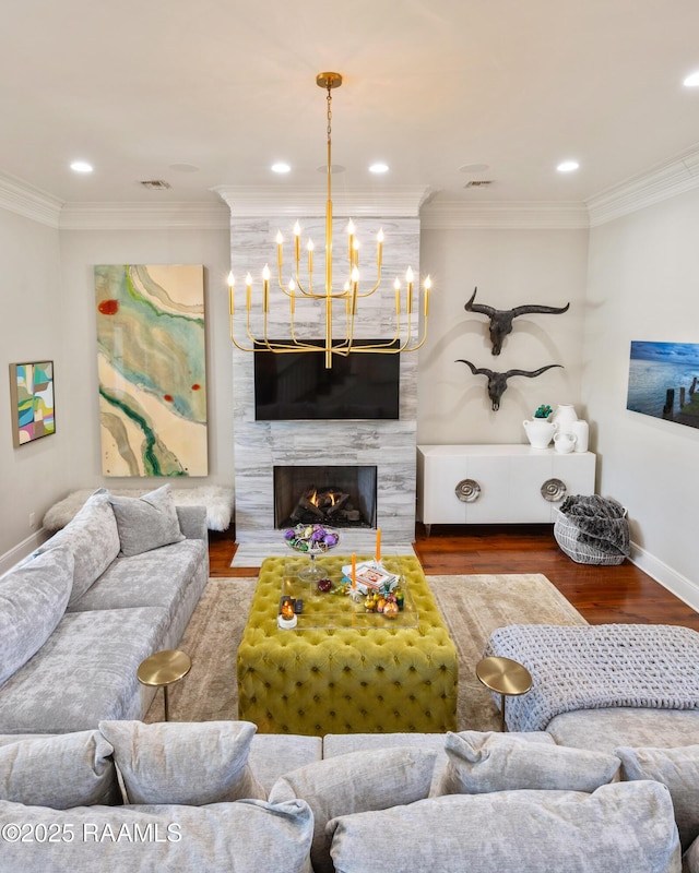 living area featuring a high end fireplace, crown molding, and wood finished floors