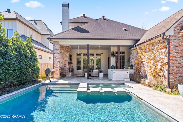 back of property featuring a patio, brick siding, roof with shingles, and fence