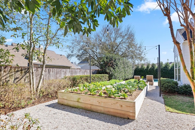 view of property's community with fence and a garden