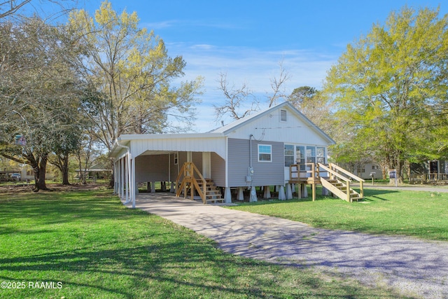 404 Senior Aly, Abbeville, LA 70510 - view of front facade with a front lawn, stairway, a carport, and driveway