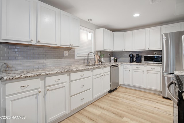 404 Senior Aly, Abbeville, LA 70510 - kitchen featuring a sink, light wood-style floors, white cabinetry, and stainless steel appliances