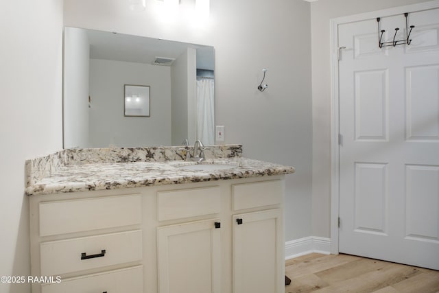 404 Senior Aly, Abbeville, LA 70510 - bathroom with visible vents, vanity, baseboards, and wood finished floors
